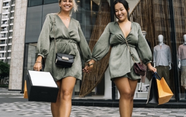 two women holding hands walking away from a store