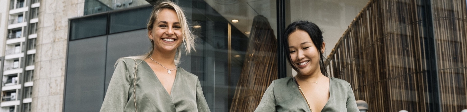 two women holding hands walking away from a store
