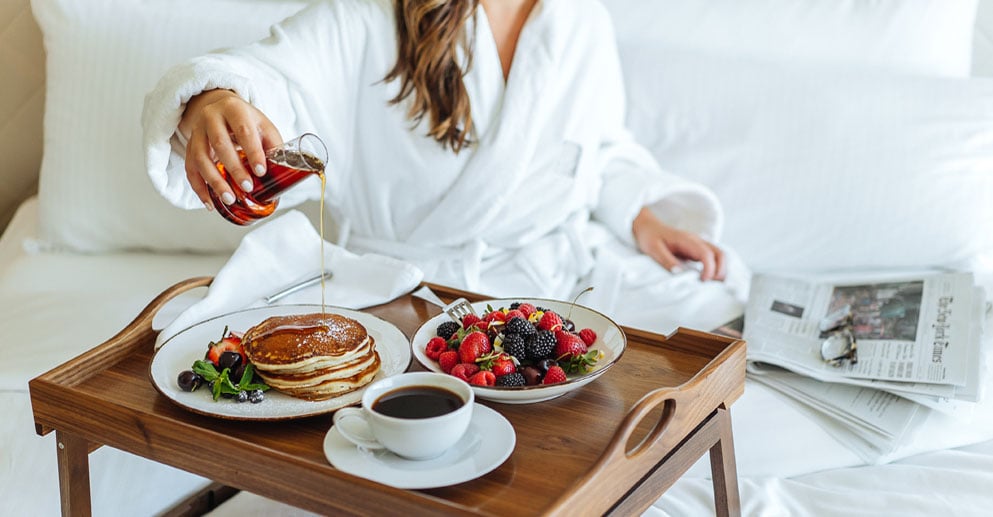 woman eating breakfast in bed