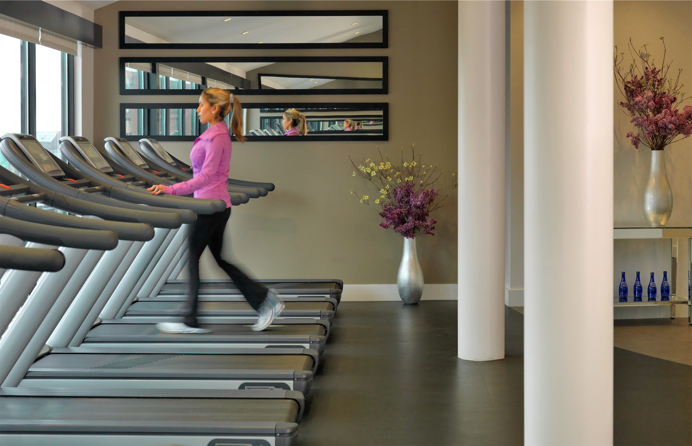 close up of a woman walking on a treadmill in the gym