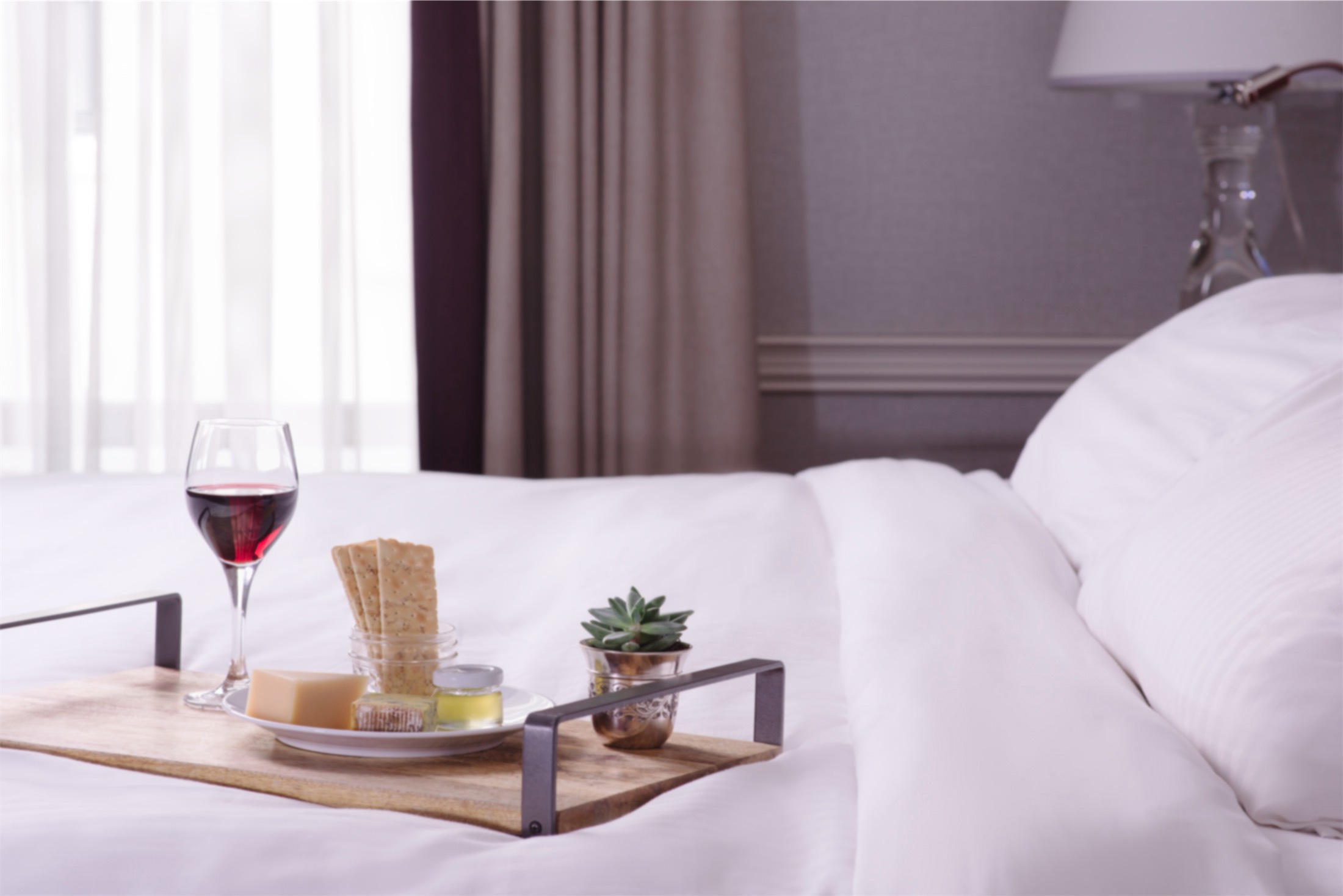 tray of cheese and crackers on a bed