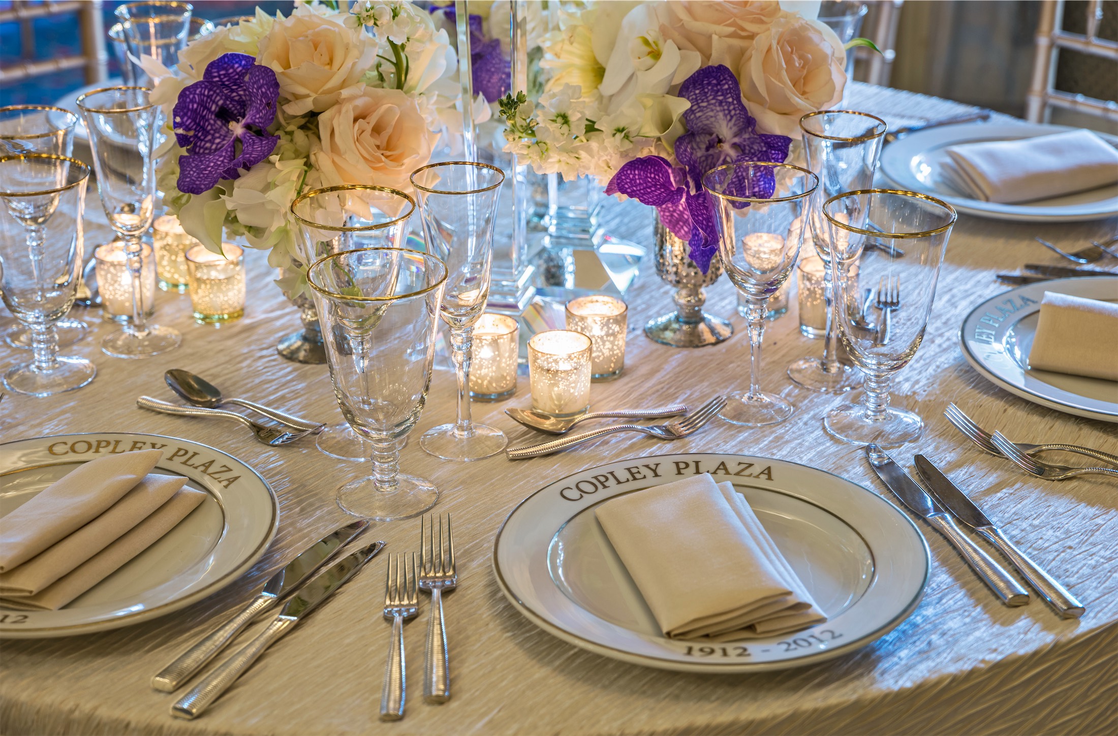 close up of a table setting with purple flowers