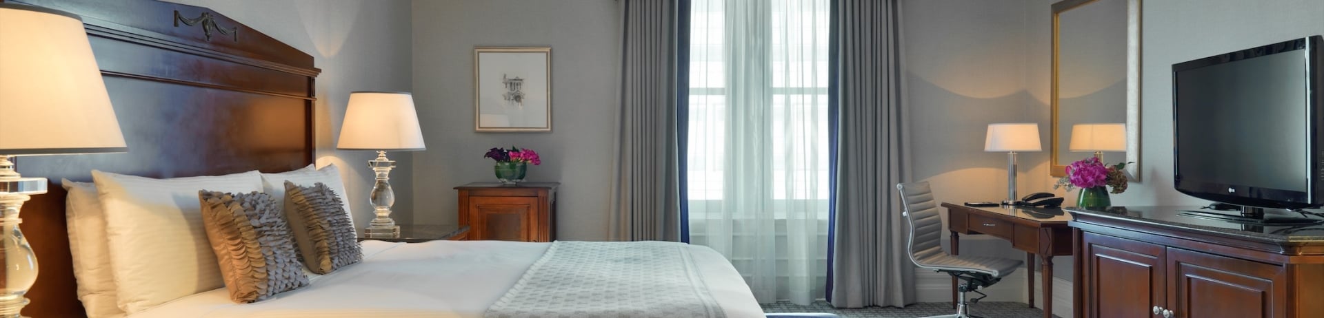 bedroom with small desk and bench at the foot of the bed