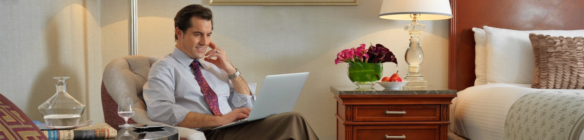 man sitting in a chair working on his laptop