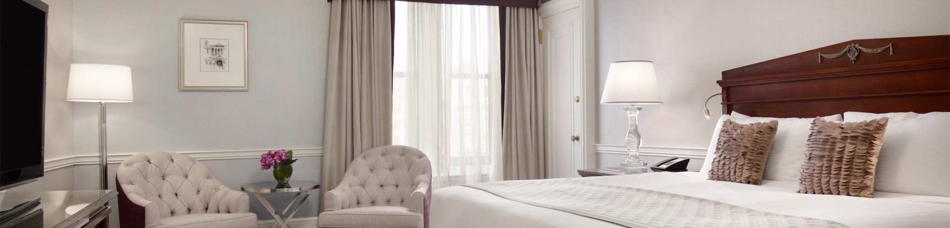 bedroom with two chairs and a bench at the foot of the bed