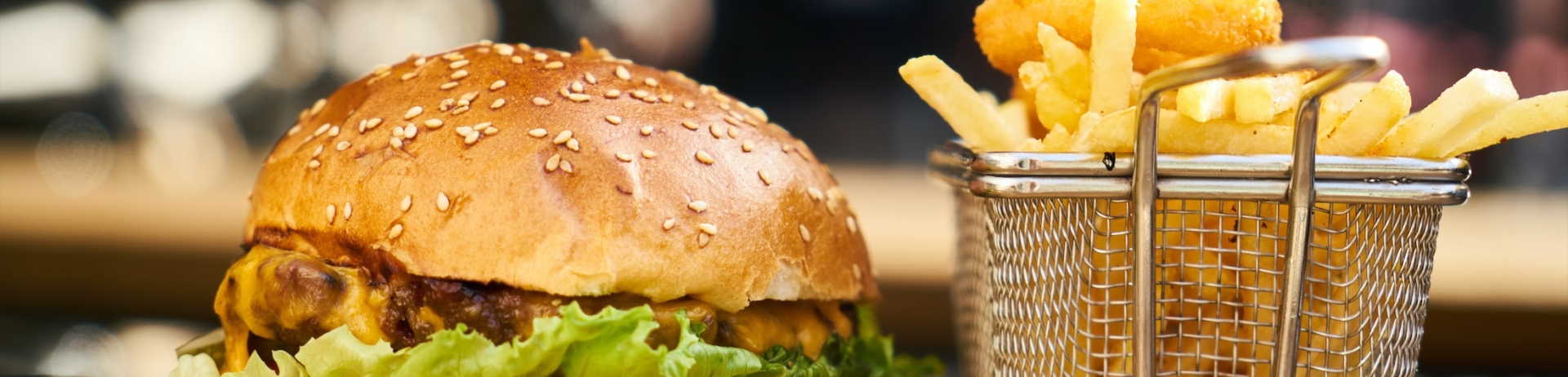 a burger and fries on a wooden cutting board
